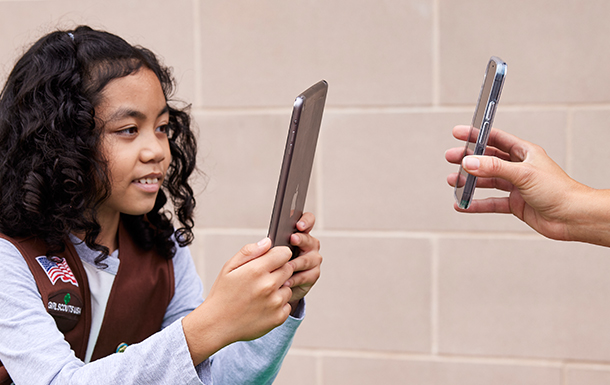 Girl Scout selling cookies with cell phone